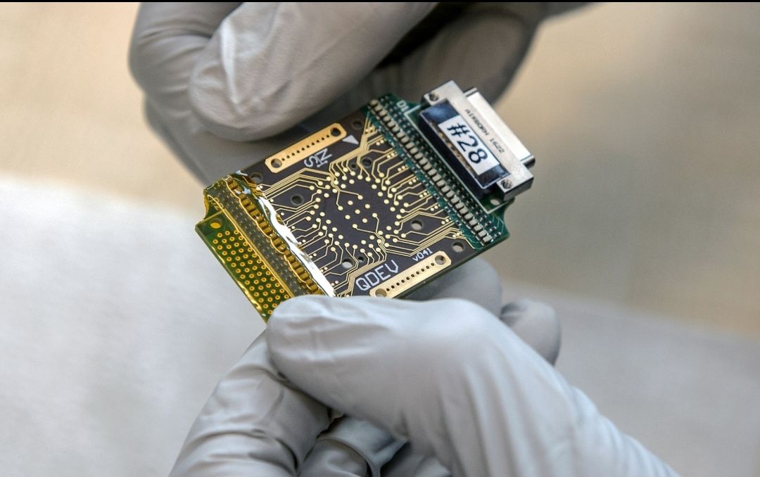 Engineer handling a precision semiconductor device in a laboratory